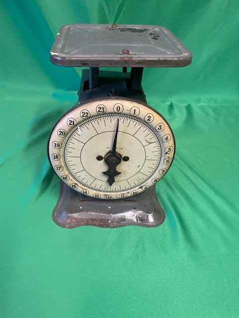 A vintage scale with an analog clock on top of it.