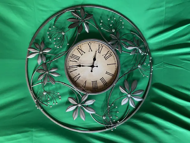 A clock with flowers and leaves on it